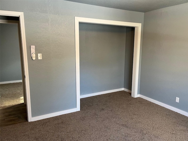 unfurnished room with dark colored carpet