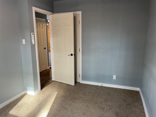 unfurnished bedroom featuring dark colored carpet