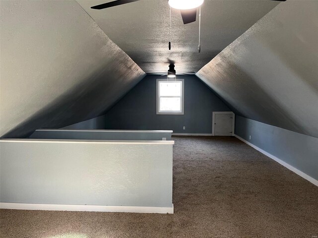 bonus room with ceiling fan, carpet flooring, vaulted ceiling, and a textured ceiling