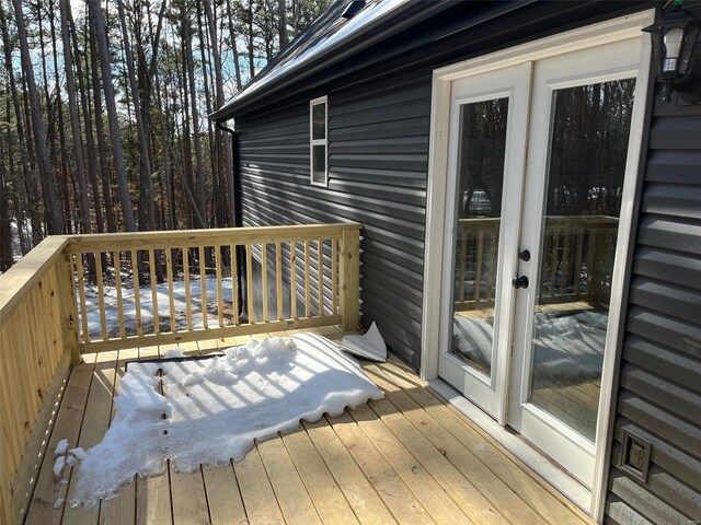 snow covered deck with french doors