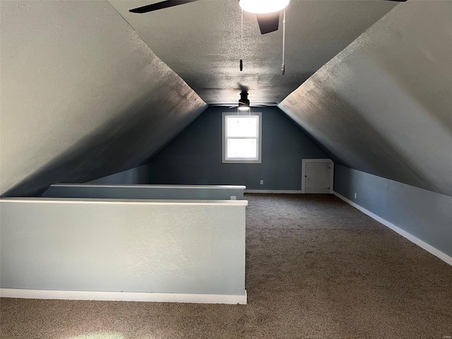 bonus room featuring lofted ceiling, a ceiling fan, a textured ceiling, carpet floors, and baseboards