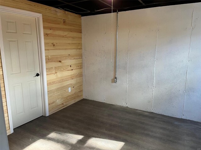 empty room with wooden walls and dark wood-style floors