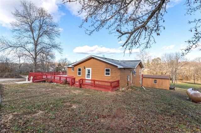 view of home's exterior with a lawn, a deck, and an outdoor structure