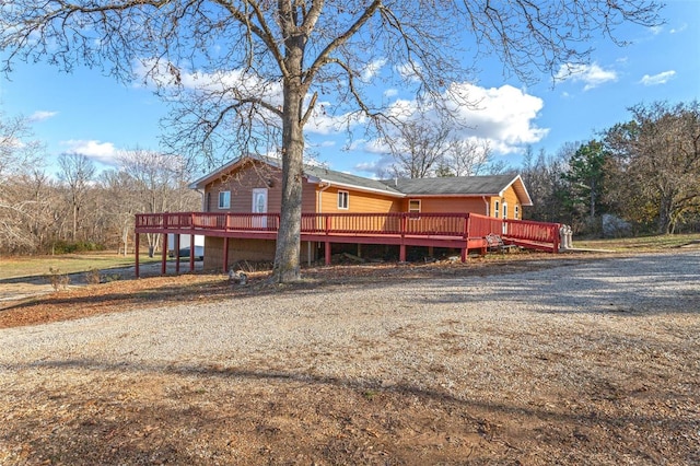 rear view of property featuring a wooden deck