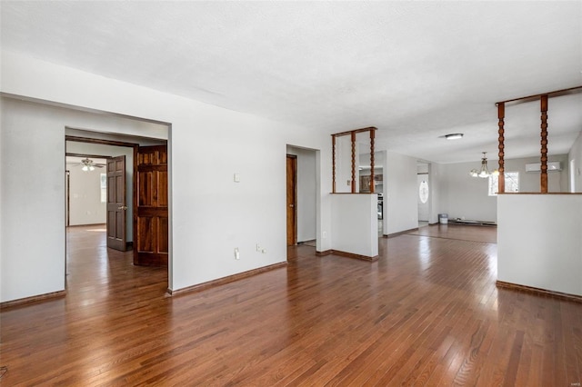 unfurnished living room featuring ceiling fan, an AC wall unit, and dark hardwood / wood-style floors