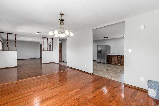 empty room featuring a chandelier and hardwood / wood-style floors