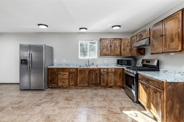 kitchen featuring sink, light stone countertops, and appliances with stainless steel finishes