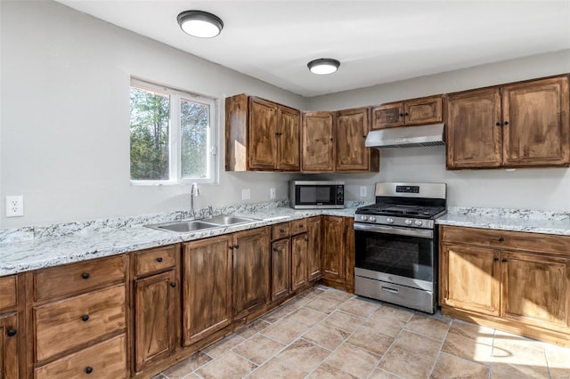 kitchen featuring light stone countertops, sink, and stainless steel appliances