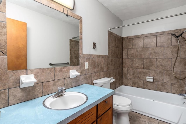 full bathroom with toilet, tile walls, tile patterned flooring, vanity, and tiled shower / bath