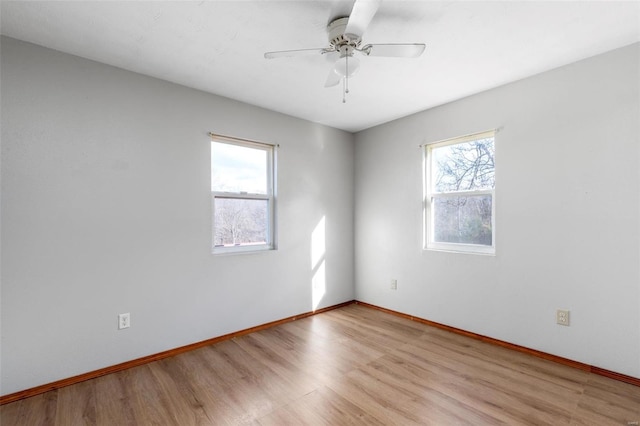 empty room with light wood-type flooring, ceiling fan, and a wealth of natural light