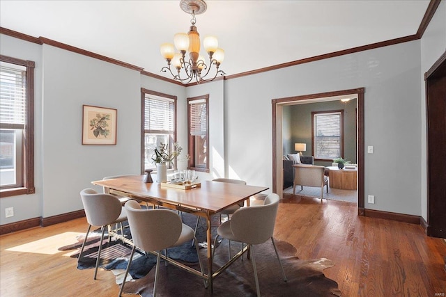 dining space with light wood-type flooring, a wealth of natural light, and ornamental molding