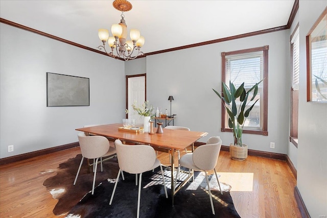 dining room featuring crown molding, a notable chandelier, light wood-style floors, and baseboards