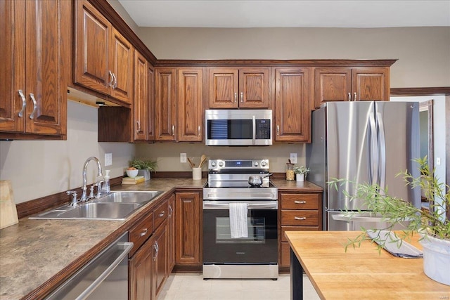 kitchen with brown cabinets, stainless steel appliances, and a sink