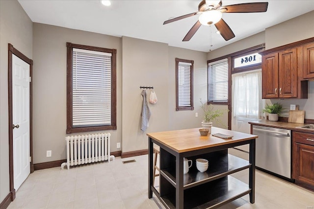 kitchen featuring visible vents, a ceiling fan, stainless steel dishwasher, radiator heating unit, and baseboards