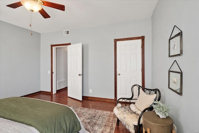 bedroom with wood finished floors, visible vents, and baseboards