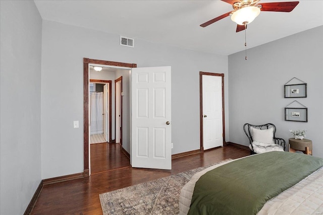 bedroom featuring a ceiling fan, wood finished floors, visible vents, and baseboards