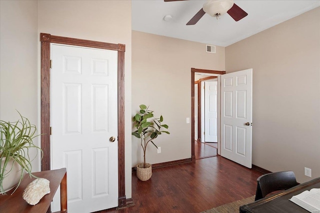 office space with a ceiling fan, visible vents, wood finished floors, and baseboards