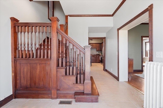 staircase with tile patterned flooring, visible vents, radiator, baseboards, and ornamental molding