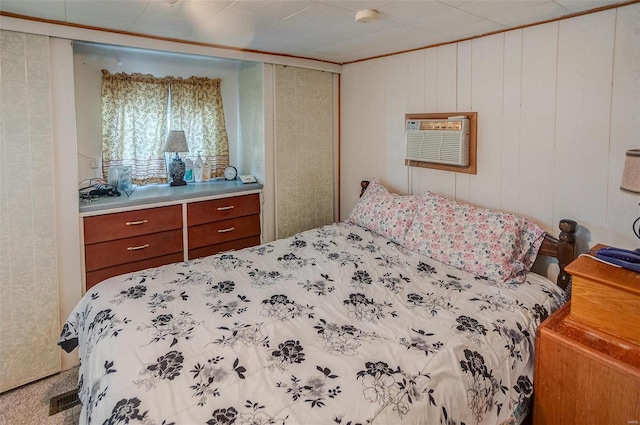 bedroom with wooden walls and a wall mounted AC