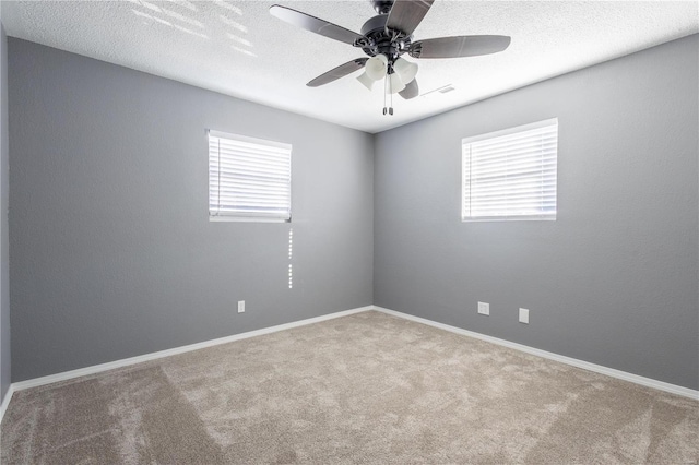 carpeted empty room with ceiling fan and a textured ceiling