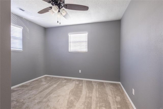 carpeted spare room featuring ceiling fan and a textured ceiling