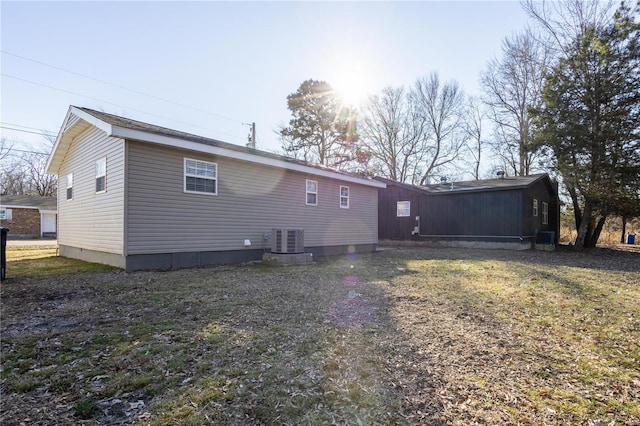 back of house with central AC and a lawn