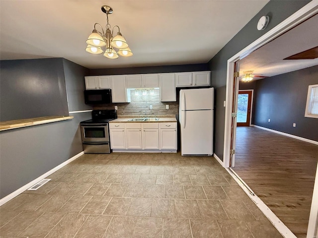 kitchen featuring pendant lighting, sink, stainless steel electric range, white cabinetry, and white refrigerator