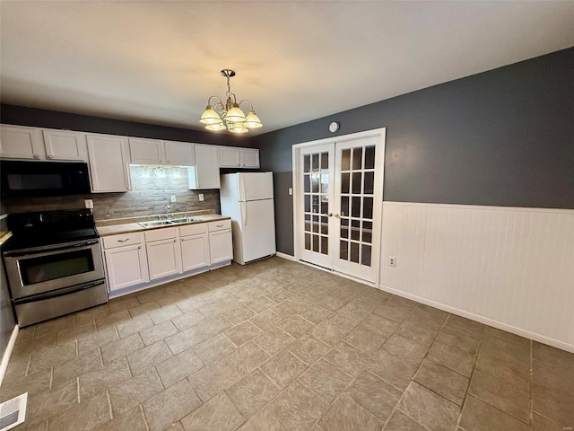 kitchen with decorative light fixtures, white cabinets, stainless steel range with electric cooktop, white fridge, and french doors