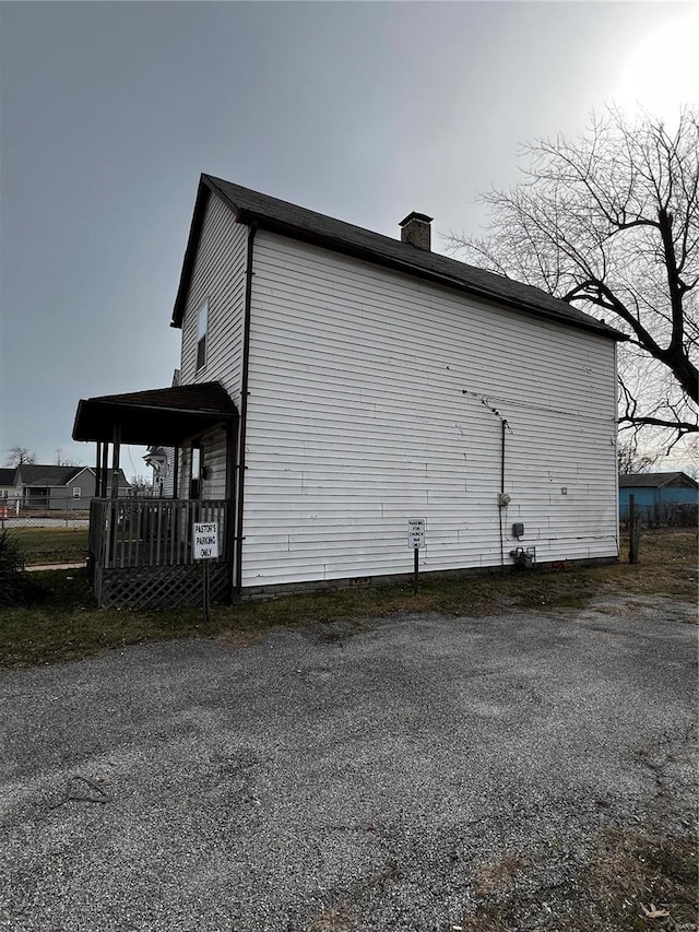 view of side of home featuring covered porch