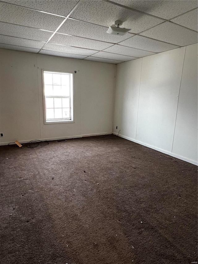 carpeted empty room with a paneled ceiling