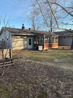 rear view of property featuring a sunroom