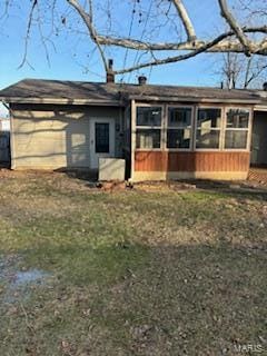 back of house featuring a yard and a sunroom