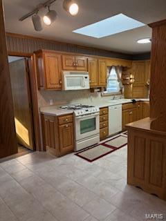 kitchen featuring sink, a skylight, white appliances, and ceiling fan