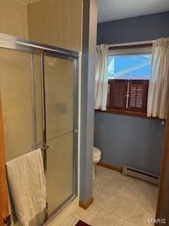 bathroom with a shower with shower door, baseboard heating, and toilet