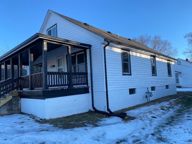 snow covered property featuring a porch