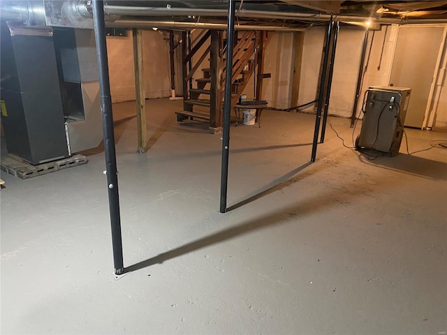 unfinished basement with heating unit and stairs