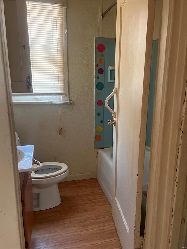 full bathroom featuring hardwood / wood-style floors, toilet, vanity, and  shower combination