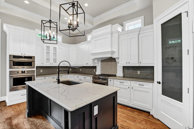 kitchen featuring ornamental molding, a sink, white cabinets, appliances with stainless steel finishes, and tasteful backsplash