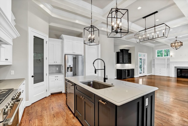 kitchen with high end appliances, coffered ceiling, a sink, white cabinetry, and open floor plan