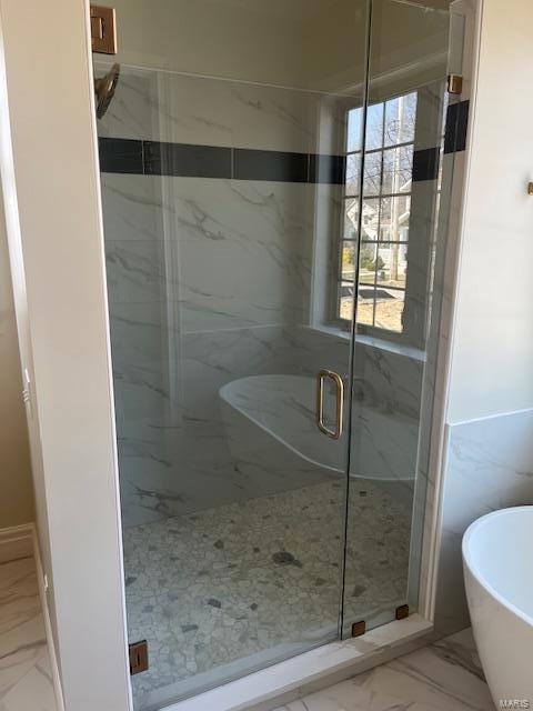 full bath with a marble finish shower, marble finish floor, and a freestanding bath