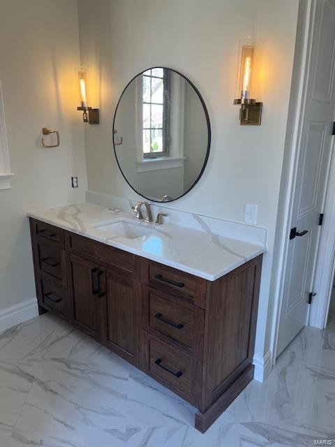 bathroom featuring baseboards, marble finish floor, and vanity