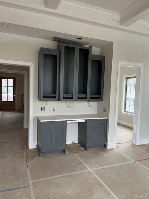 kitchen with baseboards, gray cabinetry, ornamental molding, light countertops, and beamed ceiling