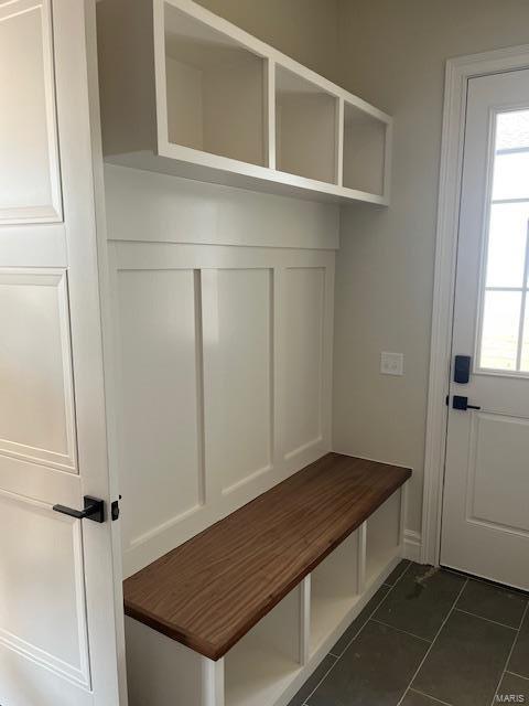 mudroom with dark tile patterned flooring and a healthy amount of sunlight