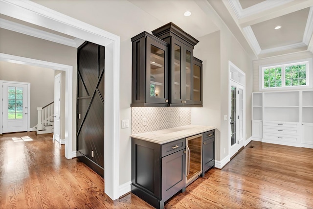 bar featuring beverage cooler, light wood-style flooring, and crown molding