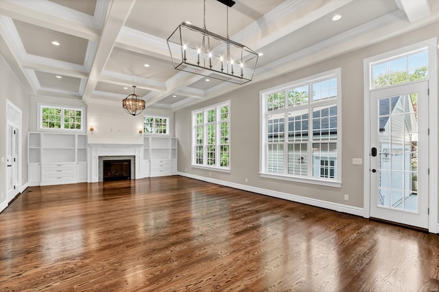 unfurnished living room with wood finished floors, beam ceiling, a chandelier, and a fireplace