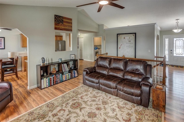 living room featuring vaulted ceiling, ceiling fan, and light wood-type flooring