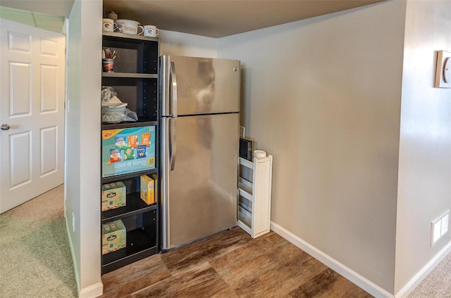 kitchen featuring carpet floors and stainless steel refrigerator