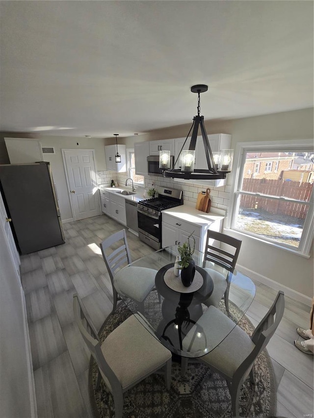 dining space featuring sink and a notable chandelier