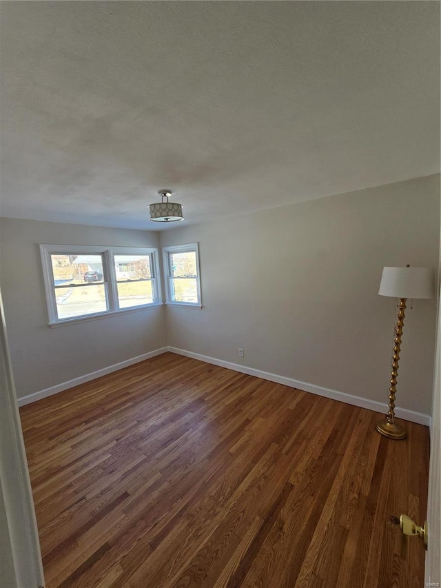 empty room with dark hardwood / wood-style flooring