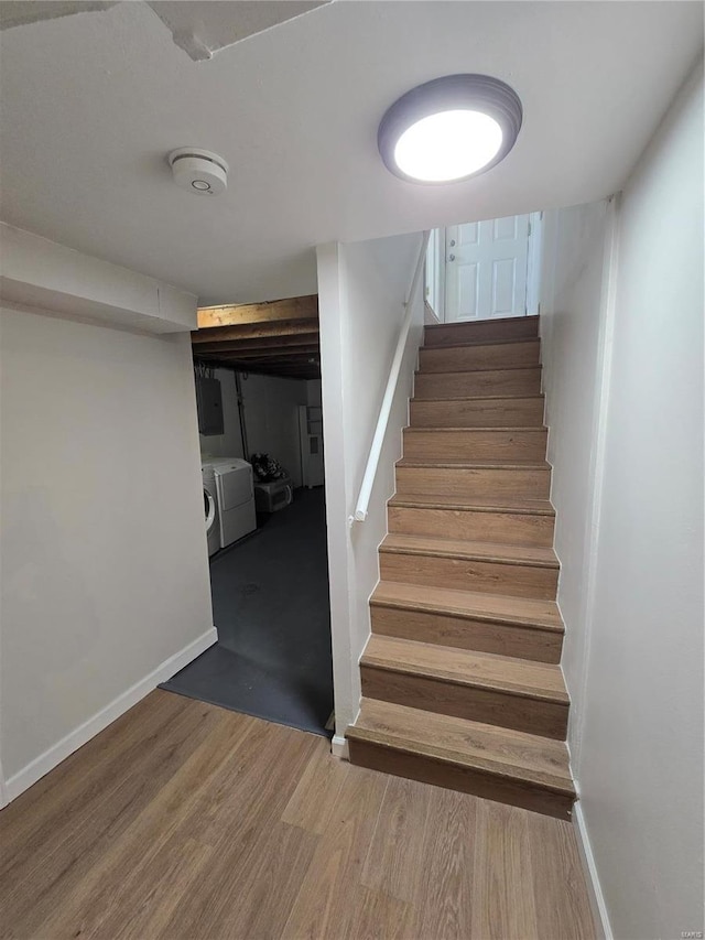 stairway featuring washing machine and dryer and hardwood / wood-style floors